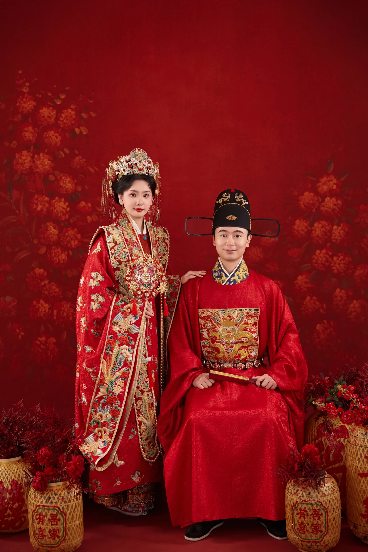 翟世雄与张欣怡身着红色中式礼服，一坐一立的合照